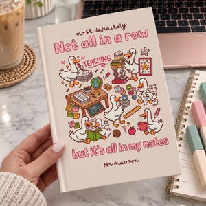 May include: A white hardcover notebook featuring a colorful illustration of cartoon ducks engaged in school activities. The text reads: most definitely Not all in a row but it's all in my notes, with the name Mrs Anderson printed at the bottom.