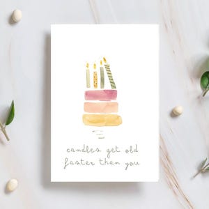Tarjeta de cumpleaños hecha a mano con un divertido pastel de acuarela: «Las velas envejecen más rápido que tú».