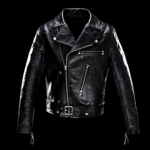 Pode incluir: Um casaco de motociclista em pele preta com gola larga, fecho de correr frontal assimétrico e ferragens em metal prateado. O casaco inclui vários bolsos com fecho, um cinto com fivela na cintura e detalhes acolchoados nos ombros.
