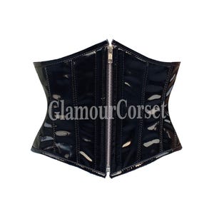 May include: Black corset with a shiny, patent leather-like finish. The corset has a silver zipper down the front and vertical seams. The text "Glamour Corset" is printed on the front.
