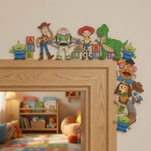 Peut inclure: Un ensemble de décorations murales en bois représentant les personnages de Toy Story : Woody, Buzz l'Éclair, Jessie, Rex, Monsieur Patate, Zigzag et des extraterrestres verts, accompagnés de blocs alphabétiques colorés et d'une fusée.