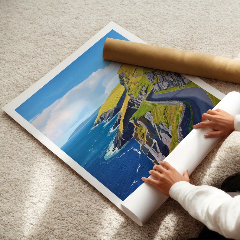 A person's hands are holding a roll of paper, which appears to be a painting of a coastal landscape with cliffs and the ocean.