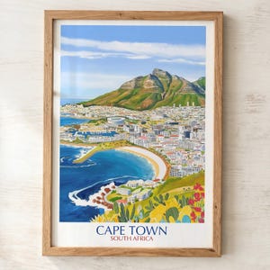 Peut inclure: Une affiche encadrée de Cape Town, Afrique du Sud, représentant une vue côtière de la ville avec une montagne en arrière-plan. L'œuvre d'art présente un océan bleu, une plage de sable et des accents floraux colorés. Le texte "CAPE TOWN SOUTH AFRICA" est en bas.