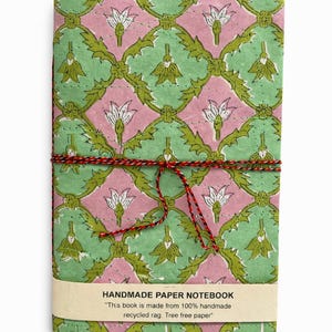 May include: A white ceramic mug with a black handle and the text "But First, Coffee" in a bold, black font. The mug is on a wooden surface. The mug is approximately 10 cm tall.