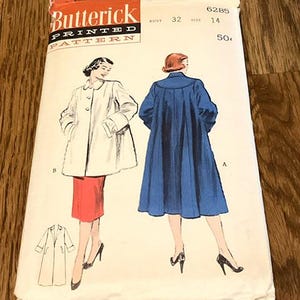 May include: Vintage Butterick printed pattern for a coat. The pattern envelope features illustrations of the coat in white and blue, with a red skirt. The envelope has the text "Butterick PRINTED PATTERN".