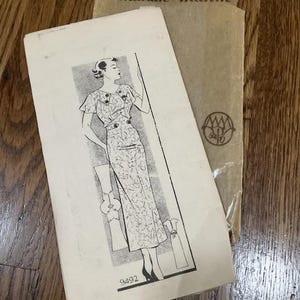 May include: Vintage sewing pattern for a dress, featuring a woman wearing a white dress with a floral print. The pattern is from Marian Martin and is numbered 9492.