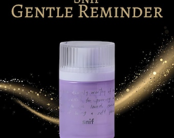 May include: A cylindrical, lavender-colored product container with a white lid. The text "SNIF GENTLE REMINDER" is at the top. The container has handwritten text on it. The background is black with gold sparkles.