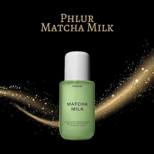 May include: A green bottle of Matcha Milk hair and body fragrance mist with a white cap. The product name is displayed in large white letters. The brand name, PHLUR, is at the top of the bottle. The background is black with gold accents.