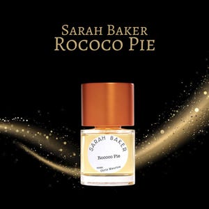 May include: A perfume bottle with a copper-colored cap and a clear glass body. The label reads "Sarah Baker Rococo Pie." The background is black with gold glitter accents. The perfume bottle is centered in the image.