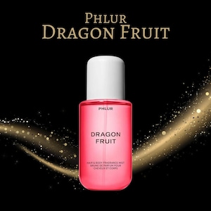 May include: A pink rectangular fragrance mist bottle with a white cap. The bottle has the text "PHLUR DRAGON FRUIT" in gold lettering. Below the text is "HAIR & BODY FRAGRANCE MIST BRUME DE PARFUM POUR CHEVEUX ET CORPS". The background is black with gold sparkles.