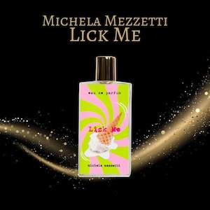 May include: A rectangular perfume bottle with a gold cap features a label with a pink and green swirl design and the words "Lick Me." An ice cream cone graphic is on the label. The words "Michela Mezzetti" and "eau de parfum" are also on the label.