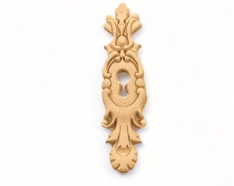 May include: A wooden keyhole cover with an ornate design. The cover is a light brown color and has a keyhole in the center.