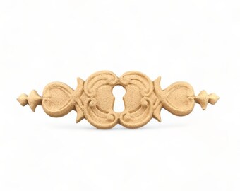 May include: A decorative wooden keyhole accent with a detailed, ornate design. The accent is a light brown color and has a keyhole shape in the center.