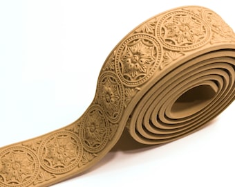 May include: A roll of decorative trim with a beige color and a repeating pattern of ornate circles and floral designs.