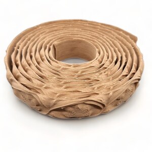May include: A roll of brown paper tape with a decorative pattern. The tape is coiled and ready to be used for packaging or crafts.