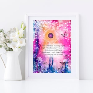 May include: A watercolour print with a pink, purple and blue background. The print features a sun with rays, butterflies and flowers. The text reads: "I am bathed in shining light high vibration surrounds me, this beautiful light heals every cell in my body, I am healthy and strong."