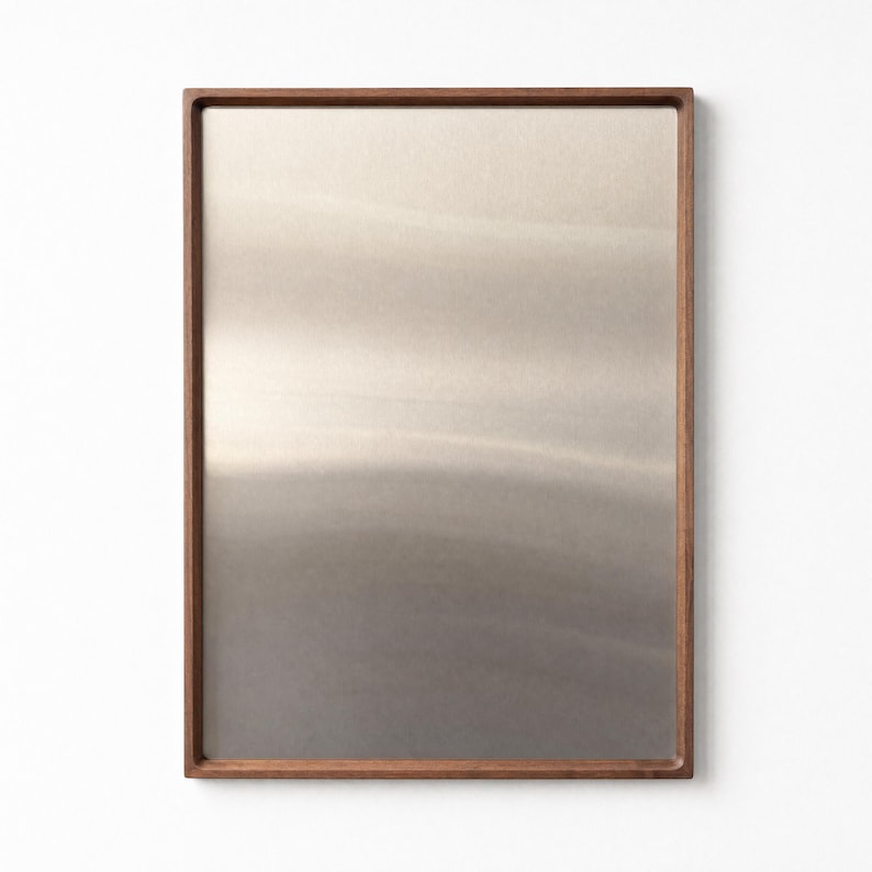 Empty walnut-framed magnetic board with a brushed stainless steel surface against a white wall.