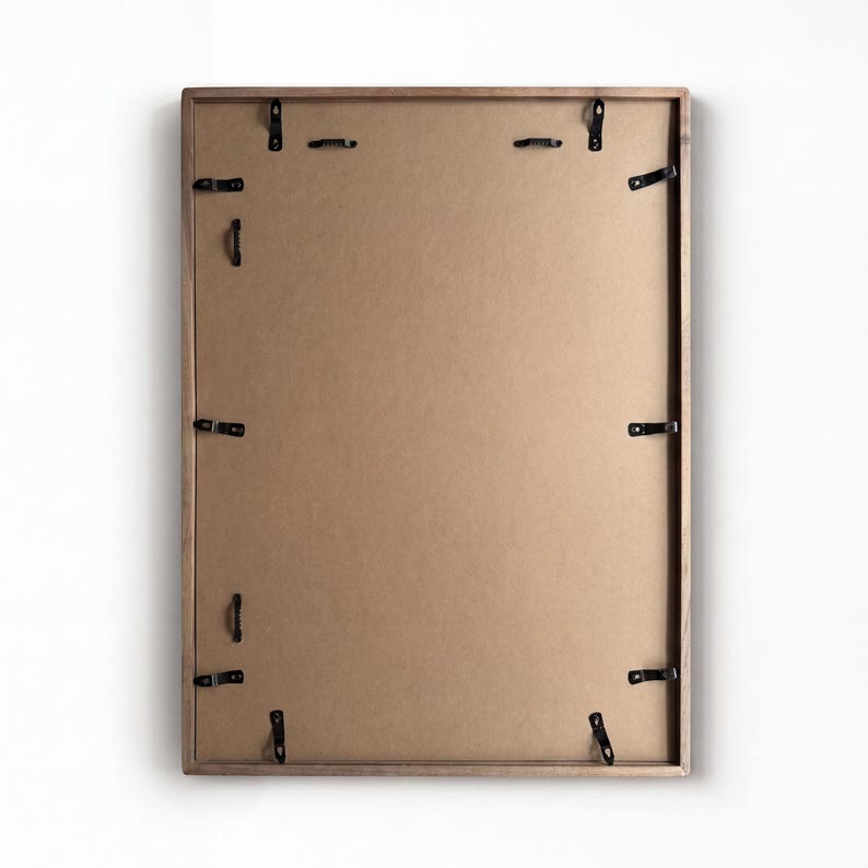 Back view of the framed magnetic board showing the brown backing board and multiple black mounting clips.