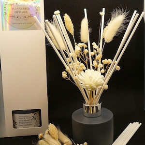 May include: A black diffuser bottle with white reeds and dried flowers. The bottle has a silver cap and the label reads "Mutantfairy Scent & Bloom Lime Basil & Mandarin Reed Diffuser".