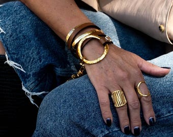 Pulsera única de cuero envolvente, pulsera vanguardista y llamativa estilo unode50 en cuero marrón con aro y brazalete de metal dorado martillado.