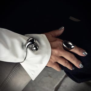 Unikt armband på handleden, elegant manschett på ärmen med stora droppar i rostfritt stål