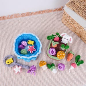 May include: Crocheted toys including a blue ocean-themed bowl with fish and starfish, a garden-themed basket with a bunny, and various vegetables. Additional crocheted fish, starfish, and jellyfish are also present. The toys are in various colors.