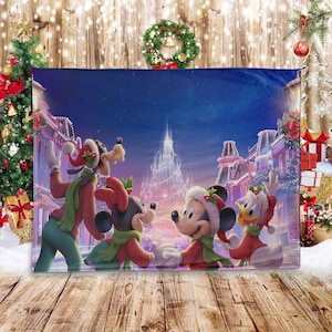 May include: A rectangular Christmas-themed blanket featuring Mickey Mouse, Minnie Mouse, Goofy, and Donald Duck in festive attire. The blanket showcases a winter scene with a castle and a town decorated for the holidays. The characters are wearing Santa hats and scarves.