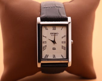 Reloj clásico Seiko Slim Vintage de cuarzo para hombre, de aspecto pulido, con esfera blanca. Incluye una batería nueva y una correa de cuero negro genuino.