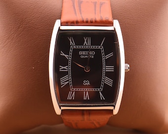 Reloj de pulsera Seiko Slim Vintage Barrel Tank de cuarzo para hombre, elaborado con precisión, con esfera negra y correa de color camello nueva.