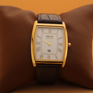 Construit pour le moment Montre-bracelet à quartz Seiko mince vintage baril pour homme avec cadran blanc et nouveau bracelet marron foncé