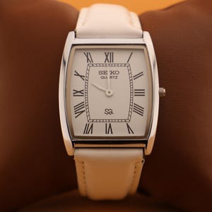 La tradition redéfinie Montre-bracelet Seiko Slim vintage à quartz pour homme Barrel Tank avec cadran blanc et nouveau bracelet blanc