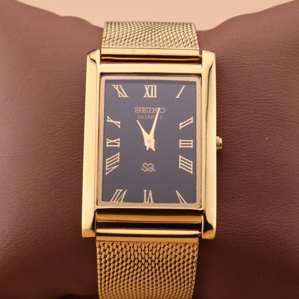 Met een vintage geïnspireerde zwarte wijzerplaat en gouden kast, gecombineerd met een bijpassende gouden schakelarmband: Seiko slim quartz herenpolshorloge