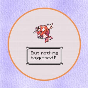 May include: A cross-stitch design featuring a pixelated orange and white fish with the text "But nothing happened!" in a black frame. The design is set within a white circle with an orange border, against a light purple background.