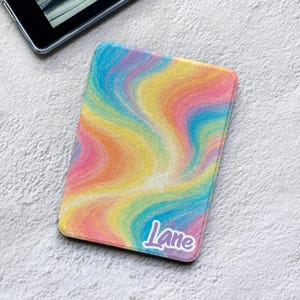 May include: A rectangular e-reader cover featuring a vibrant, swirling rainbow pattern of yellow, pink, blue, and orange hues. The word Lane is printed in a white, stylized script font with a purple outline in the bottom right corner.