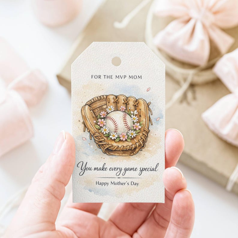 May include: A baseball-themed gift tag with a watercolour design. The tag features a baseball in a glove, surrounded by flowers. Text reads "For the MVP Mom," "You make every game special," and "Happy Mother's Day."