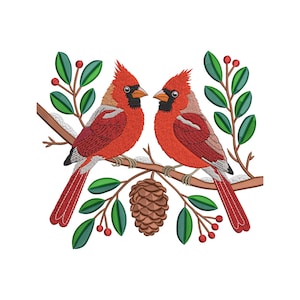 May include: An embroidered design featuring two red cardinal birds perched on a branch with green leaves, red berries, and a pinecone. The birds face each other, showcasing their vibrant red plumage and black beaks, set against a white background.
