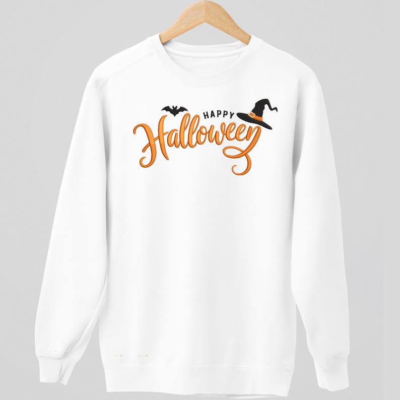 May include: White sweatshirt with the words "Happy Halloween" in orange script, a black bat, and a witch's hat. The design is centered on the front of the long-sleeved top. The sweatshirt is hanging on a wooden hanger.