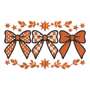 May include: An embroidered design featuring three orange bows with black outlines. The bows have different patterns: polka dots, a checkered pattern, and a solid color. The design includes orange stars and leaf accents.