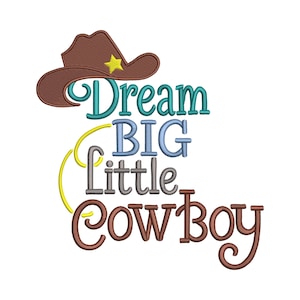 May include: A brown cowboy hat with a yellow star sits above the words "Dream BIG little Cowboy" in teal, blue, gray, and brown. The design has a whimsical, embroidered style, perfect for nursery decor or children's apparel.