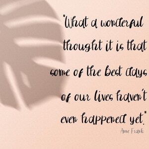 以下が含まれることがあります： 明るいピーチ色の背景に葉の影と黒の筆記体テキスト。引用文は「私たちの人生の最高の日のいくつかはまだ起こっていないという、なんと素晴らしい考えでしょう」アンネ・フランクによるものです。