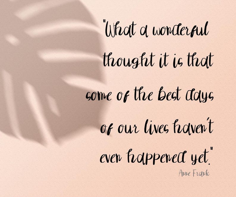 以下が含まれることがあります： 明るいピーチ色の背景に葉の影と黒の筆記体テキスト。引用文は「私たちの人生の最高の日のいくつかはまだ起こっていないという、なんと素晴らしい考えでしょう」アンネ・フランクによるものです。