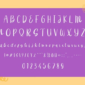 以下が含まれることがあります： 紫色の背景に、完全な白い手書きフォントセット。アルファベットは大文字と小文字で表示され、数字と記号も含まれています。黄とオレンジのデザインが左下にあり、ペーパークリップが右上にあります。