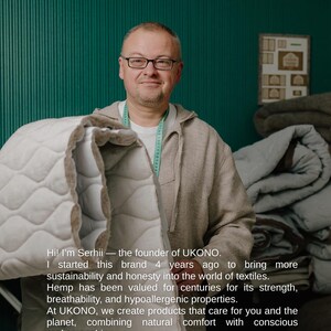 May include: A man wearing glasses and a light gray hoodie holds a white and beige quilted blanket. The text on the image reads: "Hi! I'm Serhii - the founder of UKONO... combining natural comfort with conscious craftsmanship."