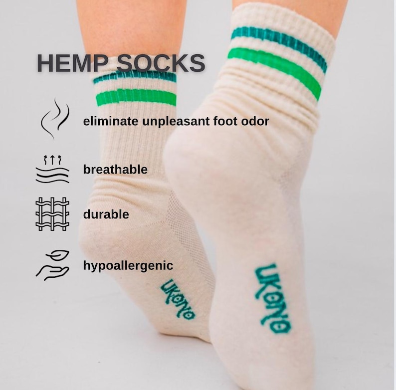 May include: Cream-colored hemp socks with green and teal stripes at the top. The text "HEMP SOCKS" is above the socks, with icons and text indicating the socks are breathable, durable, and hypoallergenic. The brand name "ukono" is printed on the side.