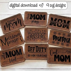 May include: Nine brown leather patches with black text. The patches feature various sayings about mums, including "Blessed Mum", "This Mum Prays", "Mum Manager of Mayhem", "Meltdown Manager", "Wife Mum Tired", "Off Duty Go Ask Your Dad", "Cool Mum", and "Mama".
