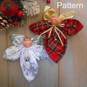 May include: Two handmade fabric angel ornaments. One angel is white with silver accents and the other is red with gold accents. Both angels have a bell hanging from their waist.