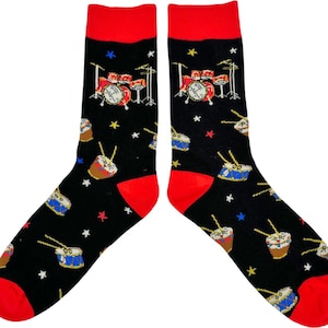May include: Black socks with red cuffs and toes, patterned with drum kits, individual drums, and stars. The drum kits are red and white, while the individual drums are brown and blue. A fun and musical accessory.