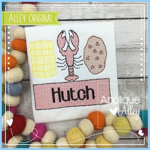 May include: Embroidered design featuring a lobster, corn on the cob, and a potato with the name "Hutch" stitched below. The design is on a white fabric background.