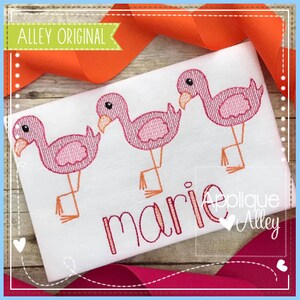 May include: Embroidered design of three pink flamingos with black eyes and beaks. The flamingos are standing on one leg with their other leg bent. The name "marie" is embroidered below the flamingos.