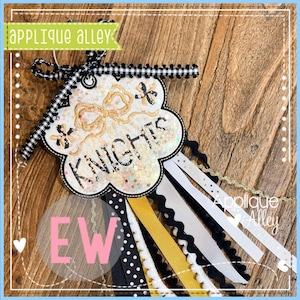 Könnte beinhalten: Handgefertigte Knights-Schleife in Weiß, Schwarz und Gold. Die Schleife zeigt das Wort "Knights", ein Vichy-Band und dekorative Bänder in verschiedenen Texturen und Mustern.